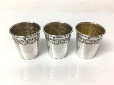 Lot 133 - Cased set of six French silver spirit cups, with swag patterns in relief and everted rims, 4cm high