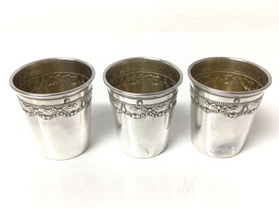 Lot 133 - Cased set of six French silver spirit cups, with swag patterns in relief and everted rims, 4cm high