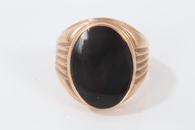 Lot 302 - 18ct rose gold signet ring with black onyx oval panel and reeded shoulders. Ring size O½