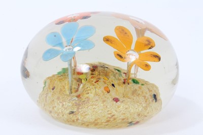 Lot 304 - Glass paperweight by Frank Eisner, with four lamp work flowers arising from a mound, 75mm diameter