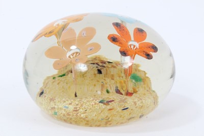 Lot 304 - Glass paperweight by Frank Eisner, with four lamp work flowers arising from a mound, 75mm diameter