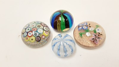 Lot 1130 - Four Italian glass paperweights, including one with 19 millefiori canes, another with lamp work flowers, another with latticino ribbons, and one more