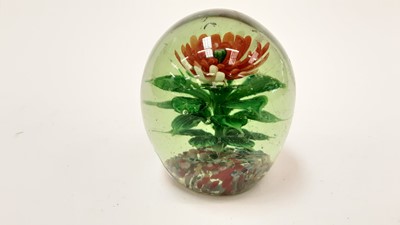 Lot 1131 - Large pale green glass doorstop / paperweight encasing a rising single lampwork flower and leaves, 120mm high