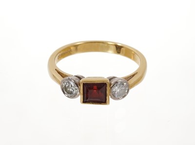 Lot 586 - Garnet and diamond three stone ring with a square step cut garnet flanked by two round brilliant cut diamonds in platinum rub-over setting on 18ct yellow gold shank.