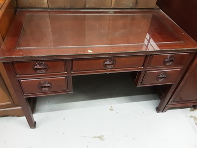 Lot 873 - Oriental hardwood kneehole writing table with plate glass top and five drawers below, 122cm wide, 61cm deep, 77cm high