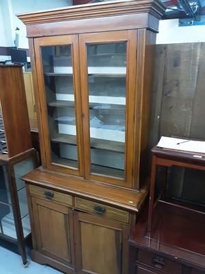 Lot 876 - Late Victorian walnut two height bookcase with shelves above enclosed by two glazed doors, two drawers and two panelled doors below, 104cm wide, 47cm deep, 217cm high